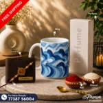 Blue wave mug hamper showcasing a custom engraved wallet, ceramic mug, perfume, Rakhi, roli, and chawal Flat lay setup of the blue wave mug hamper featuring festive accessories and personalized items