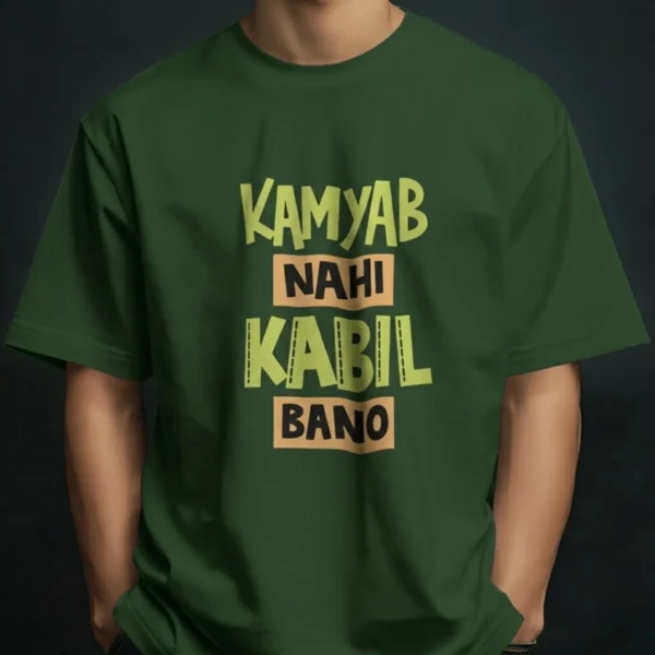 Man wearing a t-shirt featuring bold typography with the text KAMYAB NAHI KABIL BANO