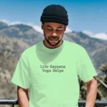 Model wearing a white life happens yoga helps t shirt outdoors against mountain background